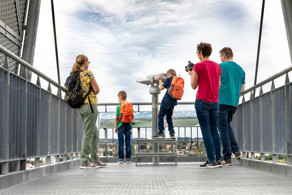 Auf der Limesplattform, ein Stahlkonstrukt, stehen fünf Personen und genießen den Ausblick. 2 Kinder stehen am Geländer vorne. Einer davon schaut durch ein Fernrohr
