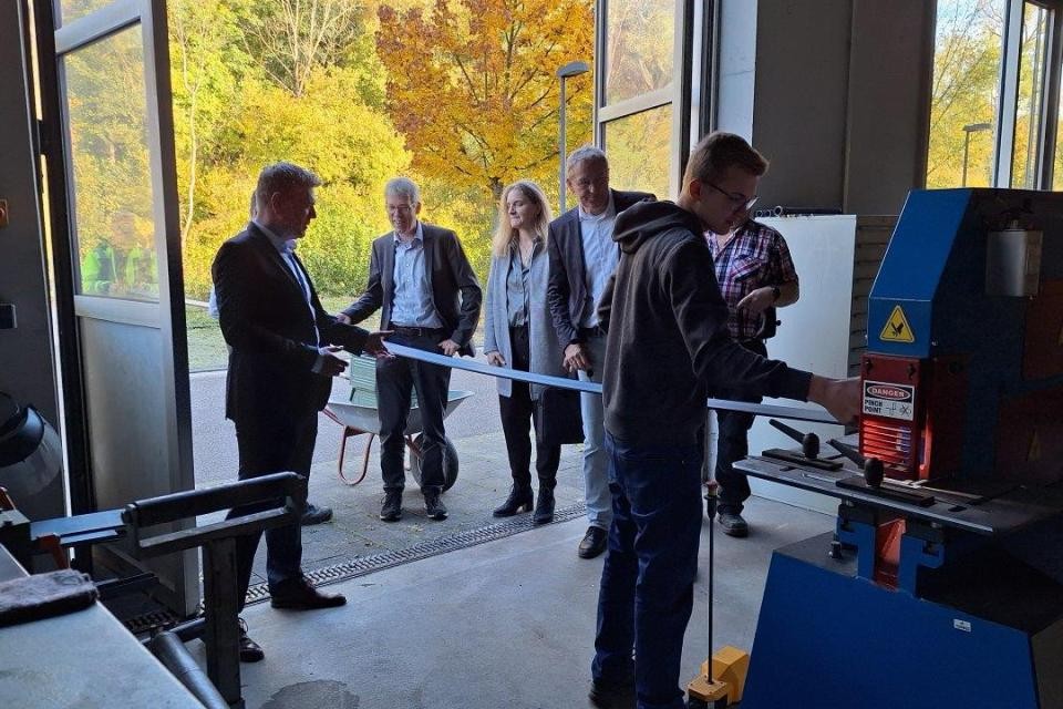 Personen stehen in der Werkstatt und erhalten Einblicke