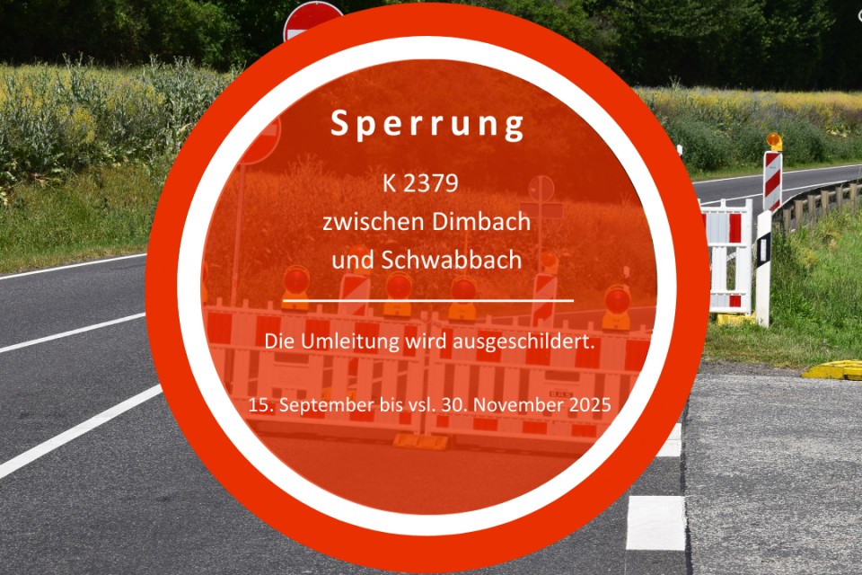 Im Hintergrund eine Straße mit Baustellenschildern, im Vordergrund ein rotes Schild mit weißer Schrift "Sperrung"