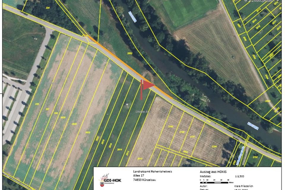 Eine Luftbildkarte zeigt Felder mit eingezeichneten Grundstücksgrenzen. Eine rote Fahne zur Kennzeichnung