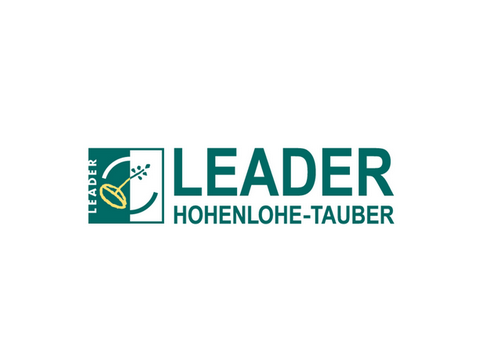 Logo des Förderprogramms Leader. Dunkelgrüne Schrift auf weißem Hintergrund: Leader Hohenlohe-Tauber. Links ein dunkelgrünes Quadrat mit weißer Hälfte .