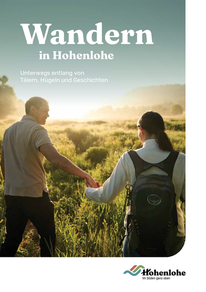 Bild der neuen Broschüre. Aufschrift in weiß: Wandern in Hohenlohe, Unterwegs entlang von Tälern, Hügeln und Geschichten. Eine Frau und ein Mann laufen Hand in Hand über eine Wiese. Unten rechts befindet sich das Logo der Touristikgemeinschaft.
