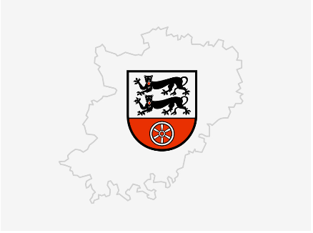 Umrisse des Hohenlohekreises in grau. In der Mitte Wappen des Hohenlohekreises. Zwei schwarze Löwen auf weisem Hintergrund. Ein weises Steuerrad auf rotem Hintergrund.