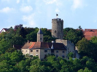 Die Krautheimer Burg ragt zwischen Bäumen empor.